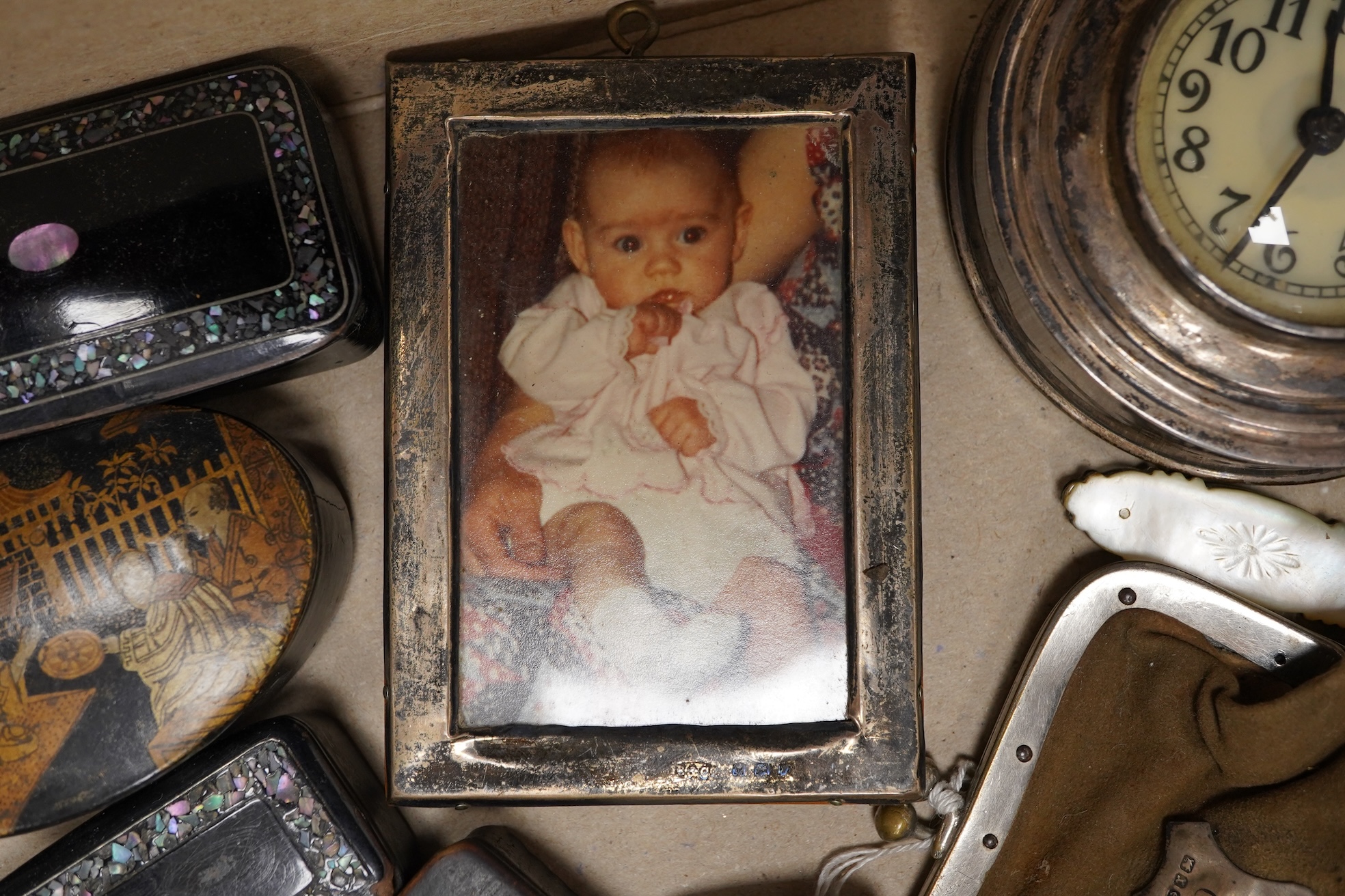 A collection of objects of vertu including snuff boxes, a pair of miniature oval trays, a silver mounted clock and photo frame, etc.